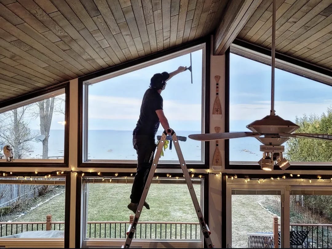 Window cleaning technician servicing high interior windows